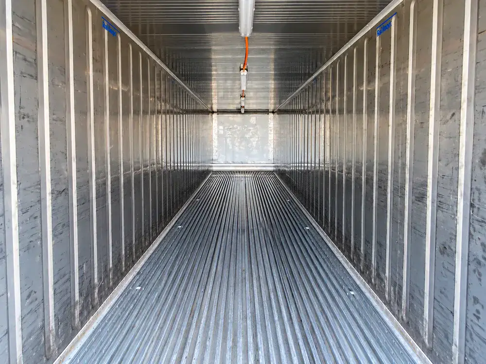 Interior de un contenedor refrigerado: paredes de aluminio corrugado, piso ranurado para el aire y conductos en el techo